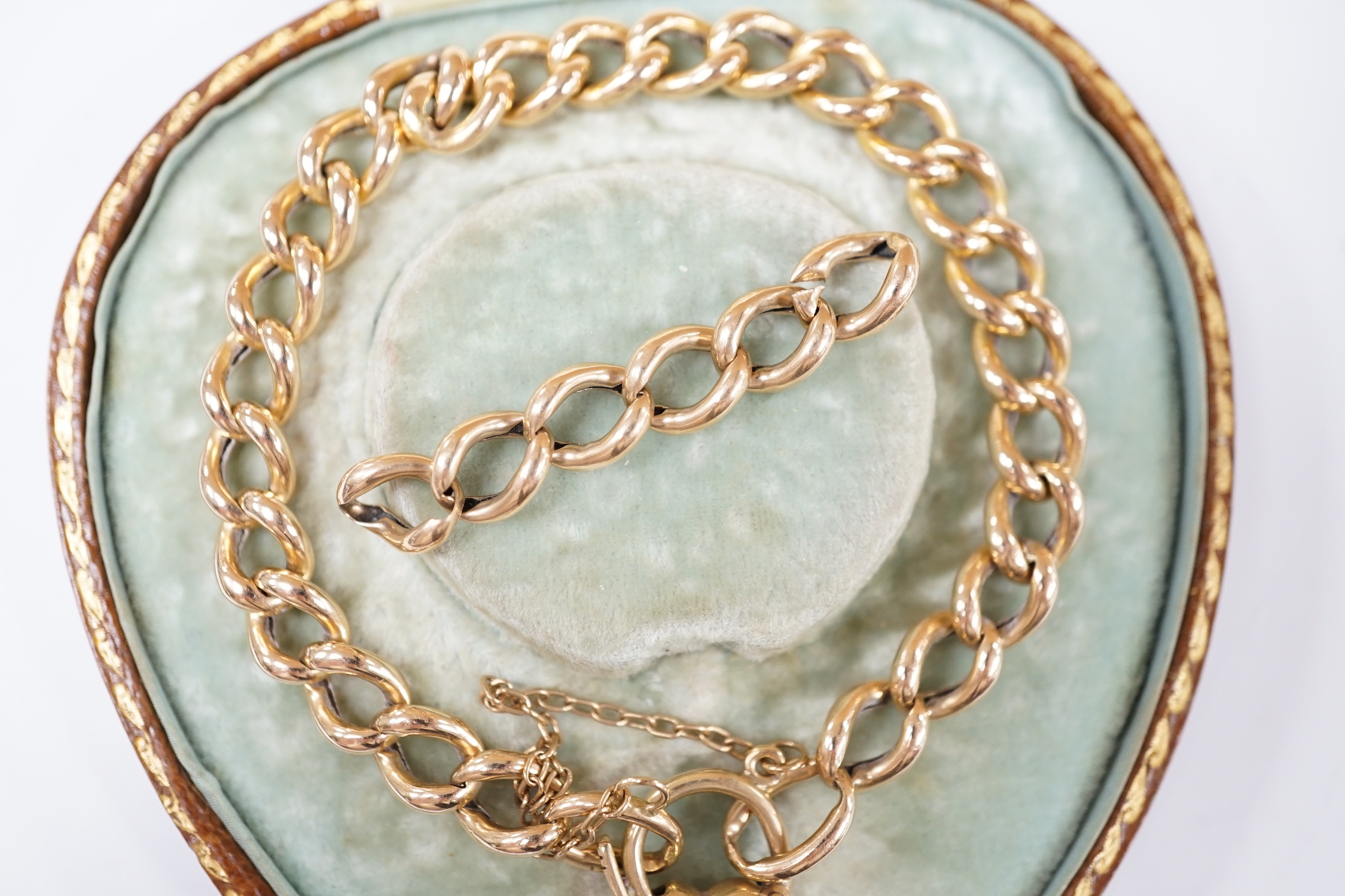 An Edwardian 15ct curblink bracelet, with sapphire set heart shaped padlock clasp, 18cm, with spare links, gross weight 13.6 grams.